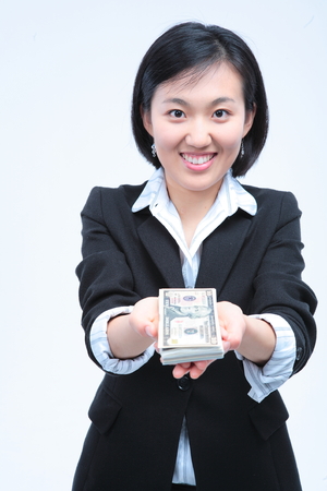 Young Asian businesswoman posing with money - isolated on whiteの写真素材