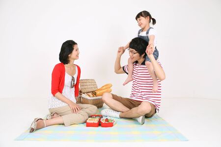 Young asian family picnic - isolated on whiteの写真素材
