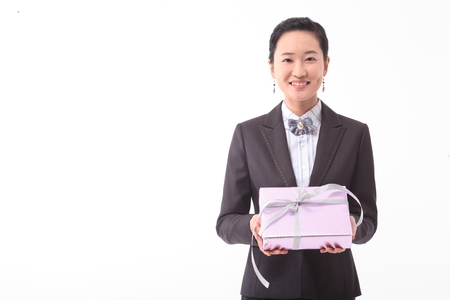 Asian businesswoman posing with a gift box - isolated on whiteの写真素材
