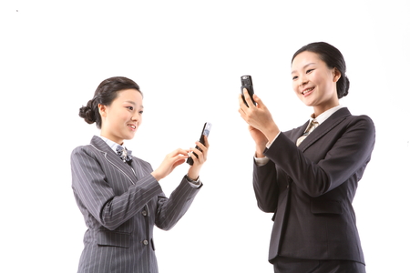 Two Asian businesswomen in uniforms posing in the studio - isolated on whiteの写真素材