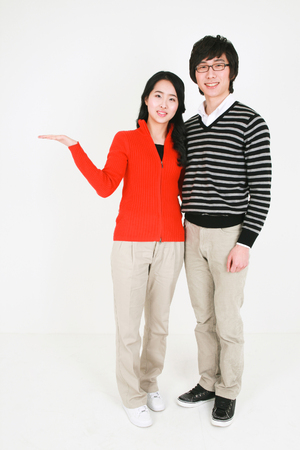 Young asian couple in a studio - isolated on whiteの写真素材