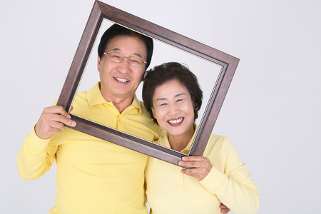 Old asian couple's happy daily life - isolated on whiteの写真素材