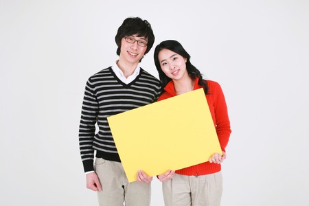 Young asian couple in a studio - isolated on whiteの写真素材