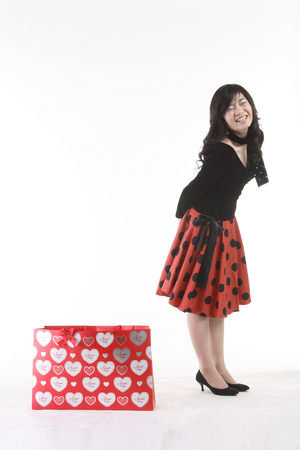 Young Asian girl posing with a shopping bag - isolated on whiteの写真素材