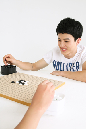 Asian couple playing game in studio - isolated on whiteの写真素材