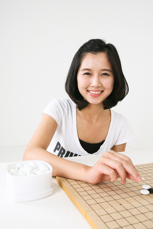 Asian couple playing game in studio - isolated on whiteの写真素材