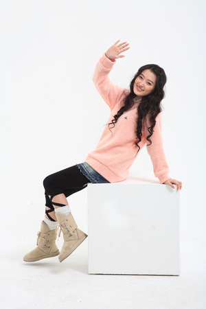 Young asian woman sitting in studio - isolated on whiteのeditorial素材