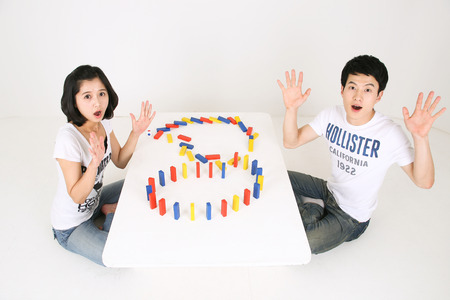 Asian couple playing game in studio - isolated on whiteの写真素材