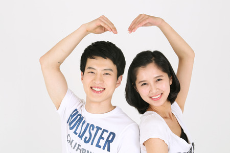 Asian couple playing game in studio - isolated on whiteのeditorial素材