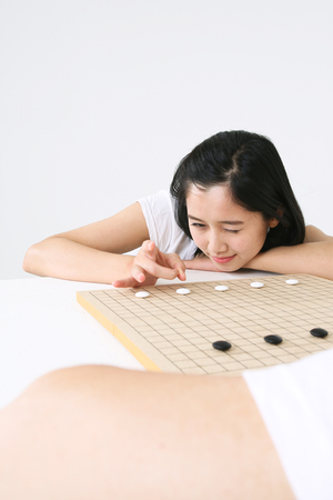 Asian couple playing game in studio - isolated on whiteの写真素材