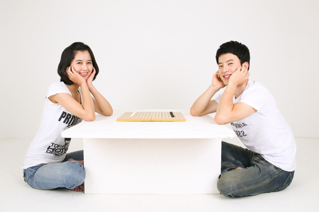 Asian couple playing game in studio - isolated on whiteの写真素材