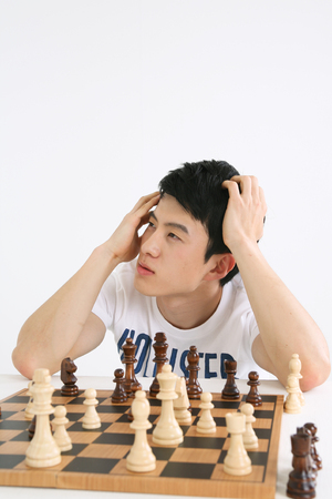 Asian couple playing game in studio - isolated on whiteの写真素材