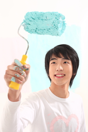 Young asian man painting in studio - isolated on whiteの写真素材