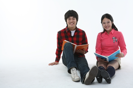 Asian college student couple studying in studio - isolated on whiteの写真素材