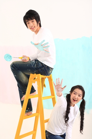 Young asian couple painting in studio - isolated on whiteの写真素材
