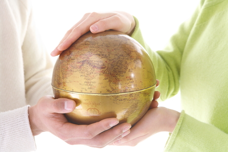 Hands holding up a globe - isolated on whiteの写真素材