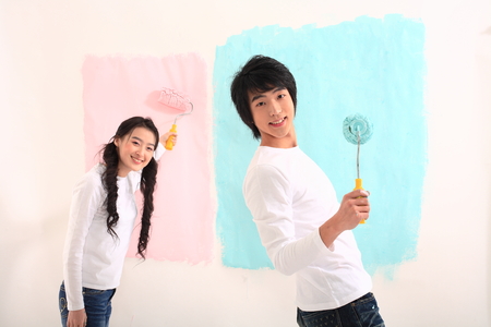 Young asian couple painting in studio - isolated on whiteの写真素材