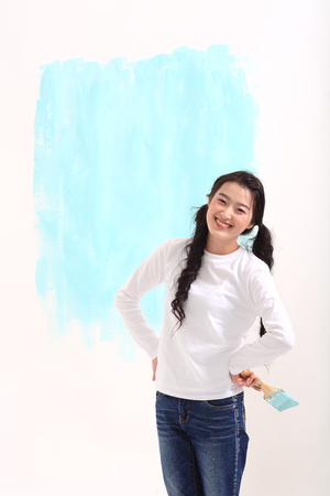 Young asian woman painting in studio - isolated on whiteの写真素材