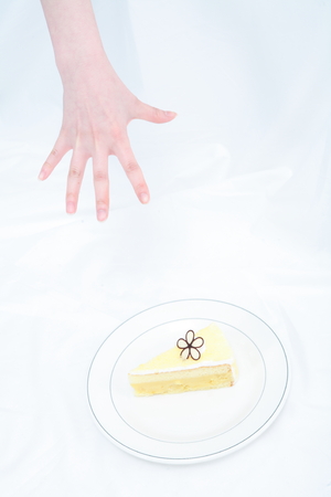Young Asian woman with a piece of cake - isolated on whiteの写真素材