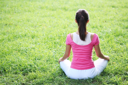 Young Asian woman doing yoga poses in the parkの写真素材