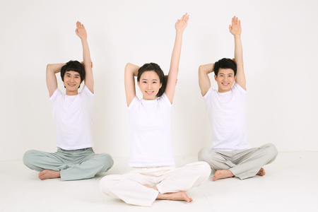 Young Asian people doing yoga poses together - isolated on whiteの写真素材
