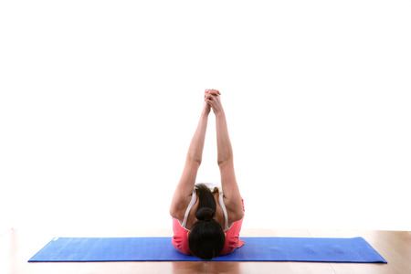 Young Asian woman doing yoga poses on mat - isolated on white