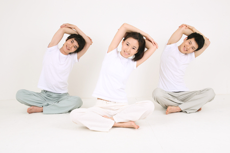 Young Asian people doing yoga poses together - isolated on whiteの写真素材