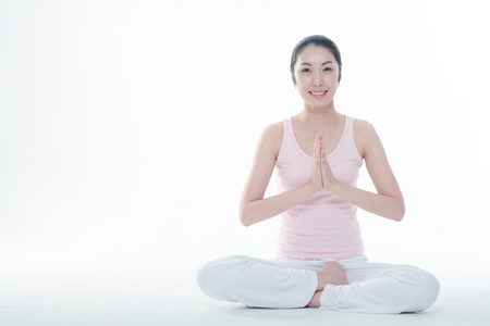 Young Asian woman doing yoga poses - isolated on whiteの写真素材