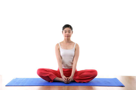 Young Asian woman doing yoga poses on mat - isolated on whiteの写真素材