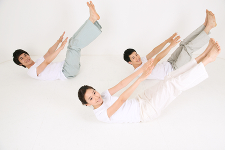 Young Asian people doing yoga poses together - isolated on whiteの写真素材