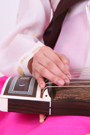 Asian woman with traditional clothing playing musical instrument - isolated on whiteの写真素材
