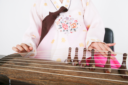 Asian woman with traditional clothing playing musical instrument - isolated on whiteの写真素材