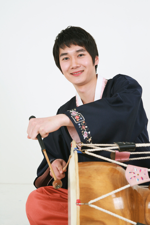 Asian man with traditional clothing playing traditional instrument - isolated on whiteの写真素材