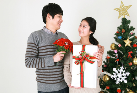 Young korean students beside christmas tree - isolated on whiteの写真素材