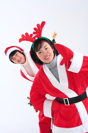 Asian couple with santa outfit - isolated on whiteの写真素材