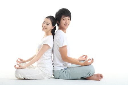 Young Asian couple working out together, doing yoga poses - isolated on whiteの写真素材