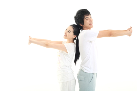 Young Asian couple working out together, doing yoga poses - isolated on whiteの写真素材
