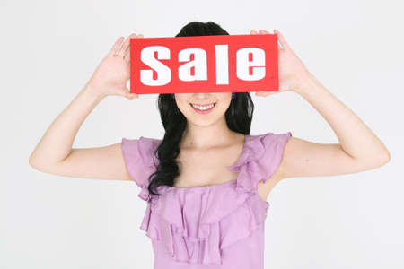 Shopping Concept - Young Asian woman posing with sale text cardの写真素材