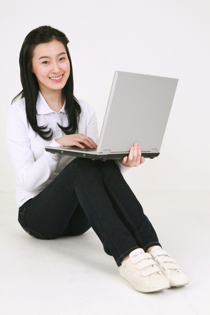 Young asian female student in studio - isolated on whiteのeditorial素材