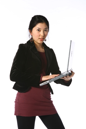 Young asian woman holding up a laptop computer in studio - isolated on whiteのeditorial素材