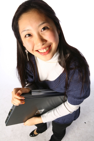 Young asian woman holding up a laptop computer in studio - isolated on whiteのeditorial素材