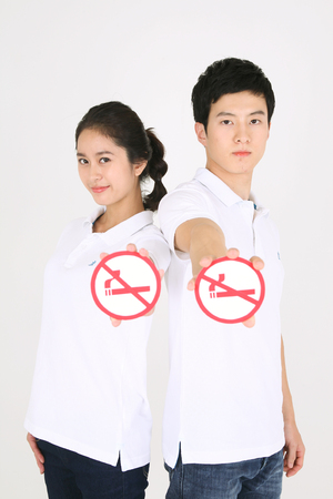No smoking concept - Young Asian couple posing with no smoking signのeditorial素材