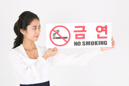 No smoking concept - Young Asian businesswoman holding NO SMOKING signの写真素材