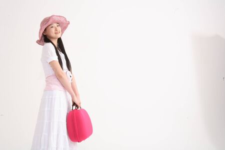 Young asian woman wearing big straw hat for picnic concept in studio - isolated on whiteの写真素材
