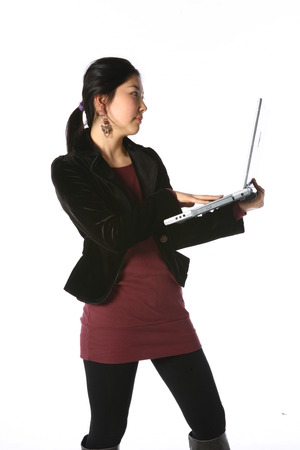 Young asian woman holding up a laptop computer in studio - isolated on whiteのeditorial素材