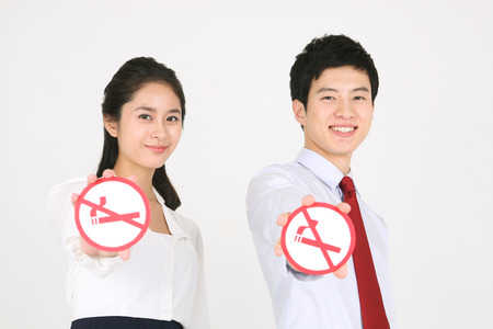 No smoking concept - Young Asian couple posing with no smoking signの写真素材