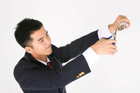 No smoking concept - Asian male student in school uniform cutting cigarettes with scissorsの写真素材