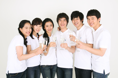 Party Concept - Young Asian people holding up champagne glasses, isolated on whiteのeditorial素材