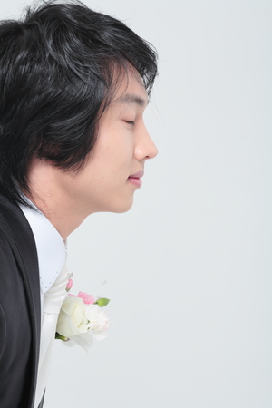 Close up shot of groom's face and boutonnieres on tuxの写真素材