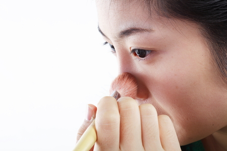 Beauty Concept - Close up shot of Asian woman applying makeup with make up toolsの写真素材